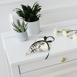 Offrez à votre intérieur ce coussin cœur déco en coton, suspendu par un ruban satiné noir. Moelleux, raffiné et facile d’entretien.