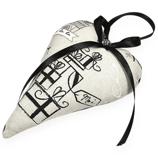 Offrez à votre intérieur ce coussin cœur déco en coton, suspendu par un ruban satiné noir. Moelleux, raffiné et facile d’entretien.