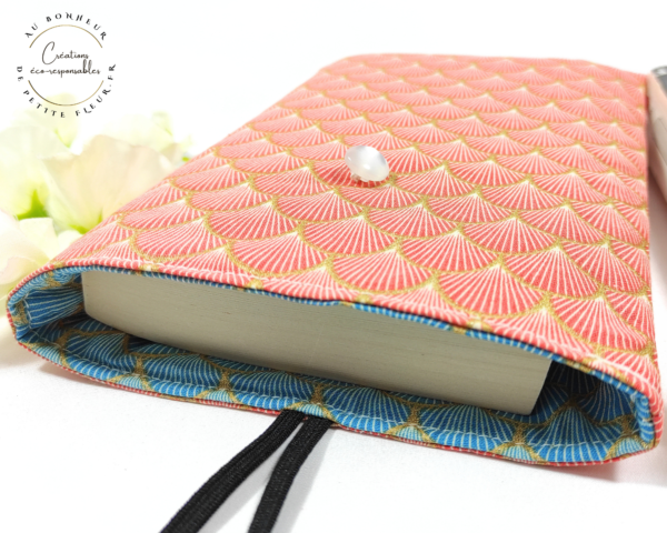 Cette Pochette pour livre de poche réversible est parfaite pour protéger votre livre et pour l'emporter sans l'abîmer. Elle est réalisée dans un tissu cretonne imprimé 100% coton biologique certifié GOTS. La Pochette est rembourrée d’une plaque de ouate. Deux marques pages Dans la pochette à livre de poche, vous pouvez y glisser un : Livre de poche de 21 cm de L sur 13,5 cm de l sur 2,5 cm d’épaisseur, Livre de poche de 18 cm de L sur 11 cm de l sur 3 cm d’épaisseur.