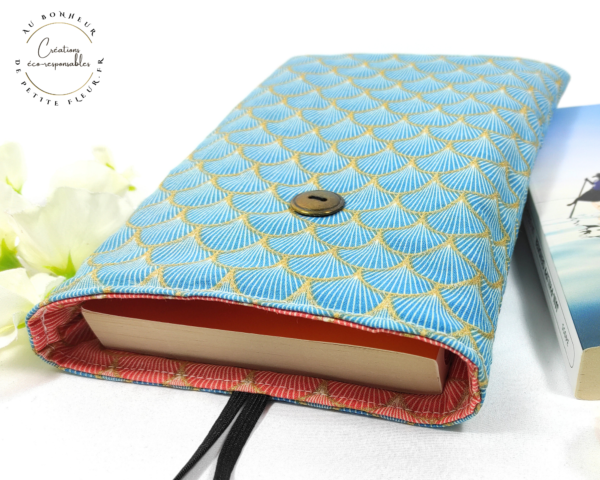 Cette Pochette pour livre de poche réversible est parfaite pour protéger votre livre et pour l'emporter sans l'abîmer. Elle est réalisée dans un tissu cretonne imprimé 100% coton biologique certifié GOTS. La Pochette est rembourrée d’une plaque de ouate. Deux marques pages Dans la pochette à livre de poche, vous pouvez y glisser un : Livre de poche de 21 cm de L sur 13,5 cm de l sur 2,5 cm d’épaisseur, Livre de poche de 18 cm de L sur 11 cm de l sur 3 cm d’épaisseur.