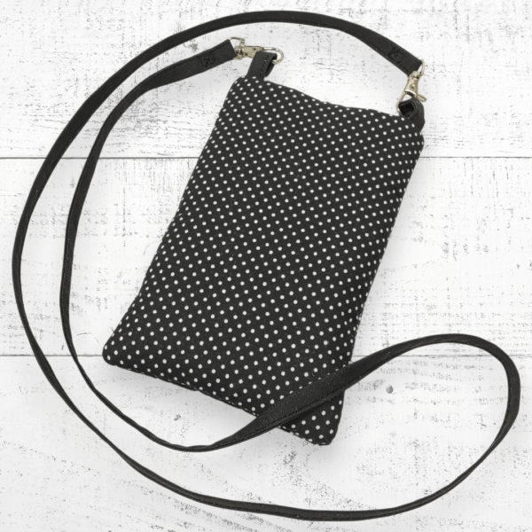 Offrez à votre téléphone une protection élégante et pratique avec cette pochette noire et blanche à bandoulière, pensée pour les femmes modernes.