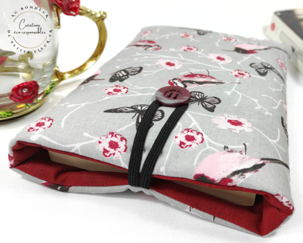 Voici une jolie Pochette livre de poche avec marque page de couleur gris et rose et imprimée "Oiseaux nostalgiques". La pochette comprend un marque page. Cette Pochette à livre de poche “ Oiseaux nostalgiques” grise et rose est parfaite pour protéger votre livre et pour l’emporter sans l’abîmer. Elle est réalisée dans un coton, Oeko-tex-standard 100, particulièrement fin et doux. La Pochette est rembourrée d’une plaque de ouate. Vous pouvez y glisser un : Livre de 11 cm de l sur 20 cm de H et 3 cm d’épaisseur.