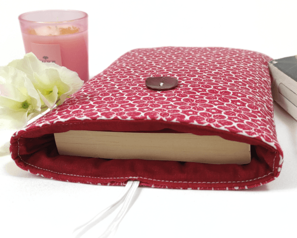 Voici une Pochette pour livre de poche "Fleur rétro" avec marque page. La pochette comprend un marque page. Cette Pochette pour livre de poche Fleur rétro avec marque page est parfaite pour protéger votre livre et pour l’emporter sans l’abîmer. Elle est réalisée dans un coton, Oeko-tex-standard 100, particulièrement fin et doux. La Pochette est rembourrée d’une plaque de ouate. Dans cette pochette, vous pouvez glisser un format livre de poche. Format livre de poche : 11 x 18 cm.